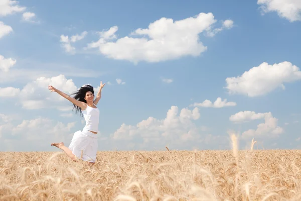 Femme heureuse sautant dans le blé doré — Photo