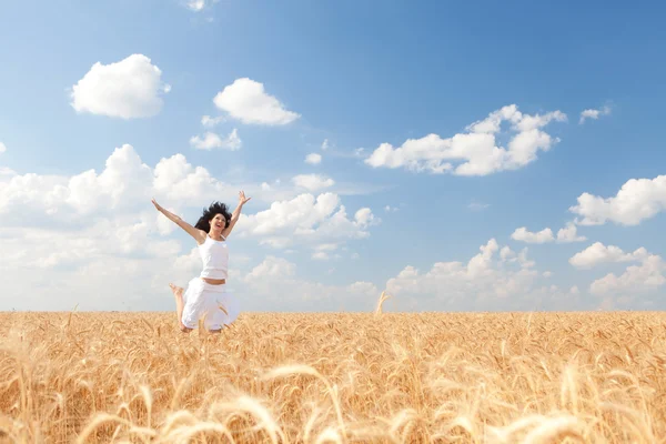 Щаслива жінка стрибає у золоту пшеницю — стокове фото