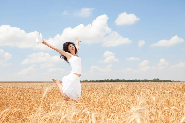 Счастливая женщина прыгает в золотой пшенице — стоковое фото