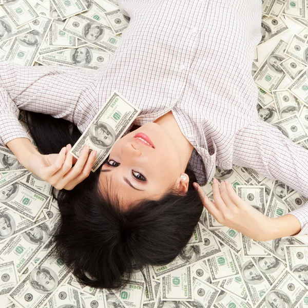 Jonge zakenvrouw rustend op geld — Stockfoto