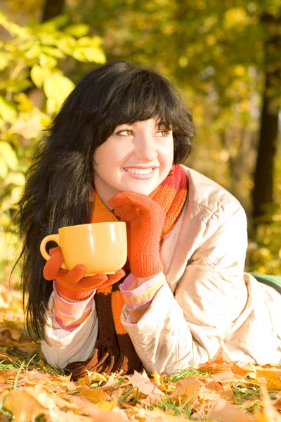 Jonge mooie vrouw met thee beker in de herfst park — Stockfoto