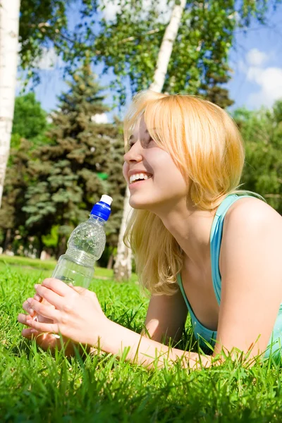 Hübsche Frau trinkt Wasser auf der Sommerwiese — Stockfoto