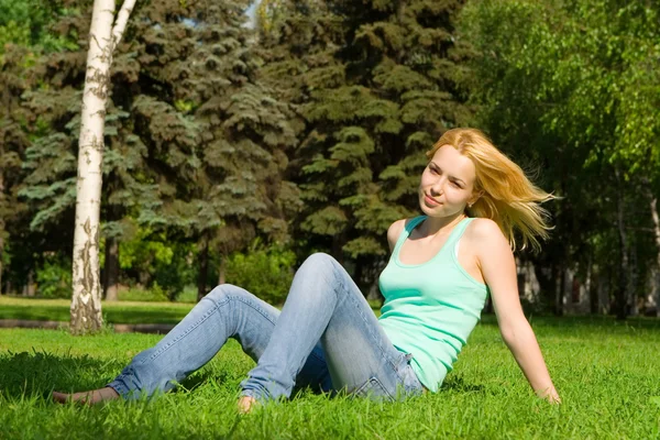 Süße Frau ruht auf dem grünen Sommergras — Stockfoto