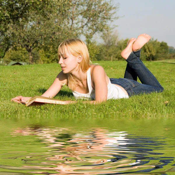 Jeune blonde lit le livre dans le parc — Photo