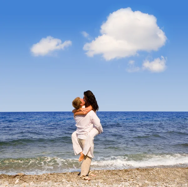 Jovem casal atraente beijos na praia — Fotografia de Stock