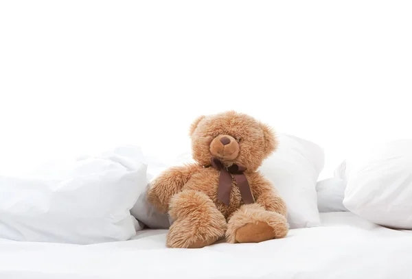 Spaß Teddybär sitzt auf Bett — Stockfoto