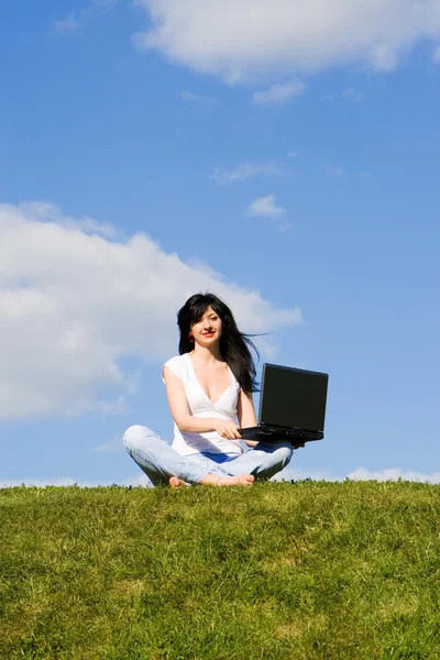 Pretty woman with laptop on the green grass Royalty Free Stock Photos