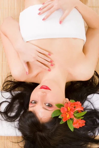 Lovely spa brunette with flowers — Stock Photo, Image