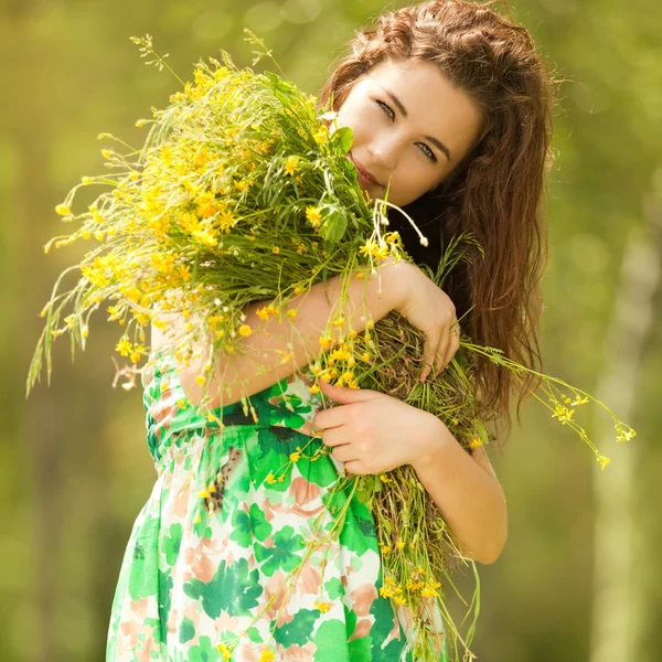 Çiçeklerle parkta genç Kızıl saçlı kadın — Stok fotoğraf
