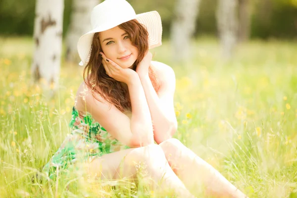 Jeune rousse femme dans le parc avec des fleurs — Photo