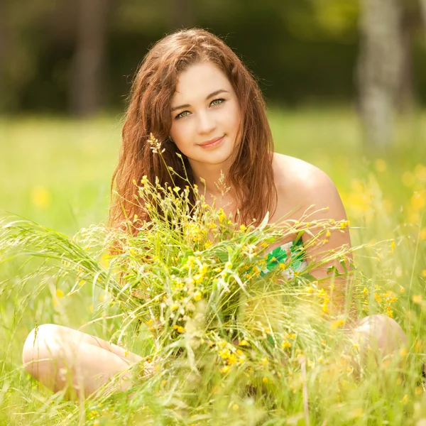 年轻的红发女子在公园的花 — 图库照片