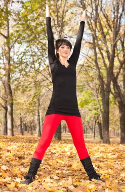 güzel bir kadın yoga egzersizleri sonbahar Park yapıyor