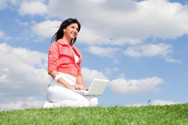sevimli kadın parkta beyaz dizüstü bilgisayar ile