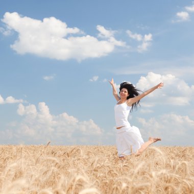 Happy woman jumping in golden wheat clipart