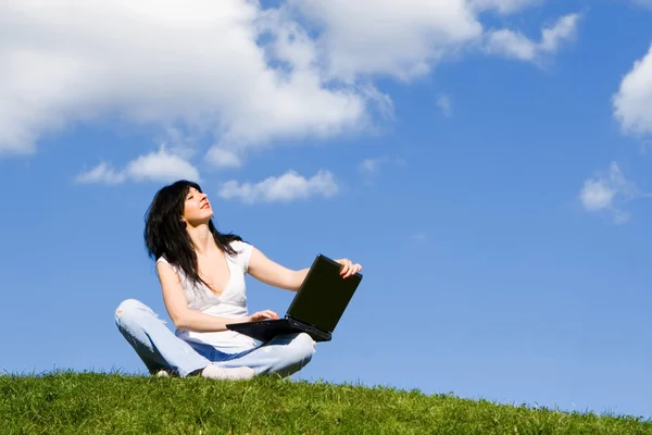 Bella donna con computer portatile sull'erba verde — Foto Stock