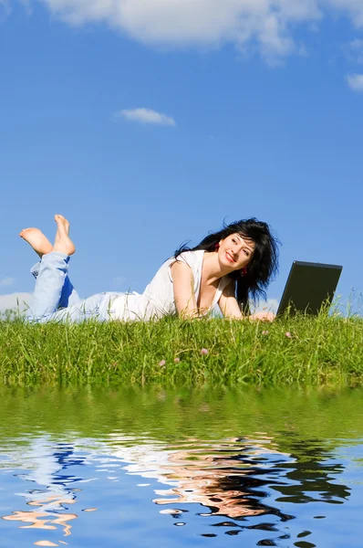 緑の芝生の上のラップトップできれいな女性 — ストック写真