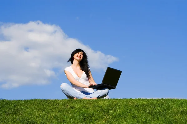 Mulher bonita com laptop na grama verde — Fotografia de Stock