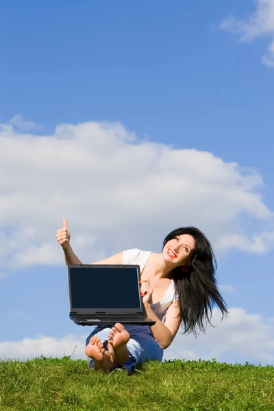 Vacker kvinna med laptop på det gröna gräset — Stockfoto