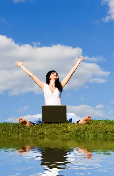 Гарна жінка з ноутбуком на зеленій траві — стокове фото