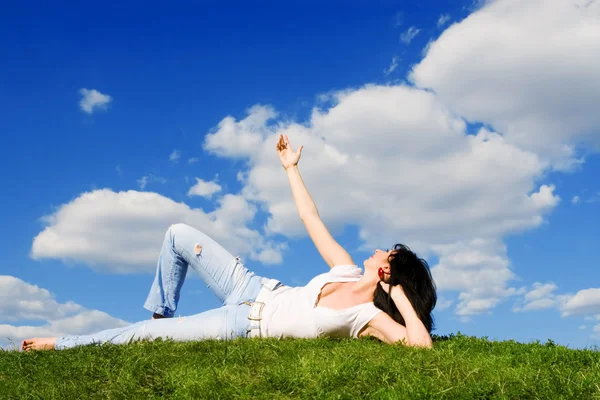 Красивая женщина отдыхает на зеленой траве — стоковое фото
