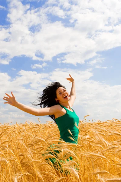 Mulher feliz pulando no trigo dourado — Fotografia de Stock