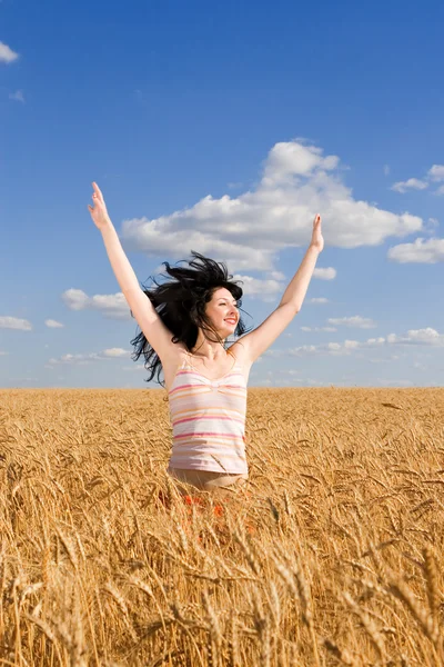 Glad kvinna hoppa i gyllene vete — Stockfoto