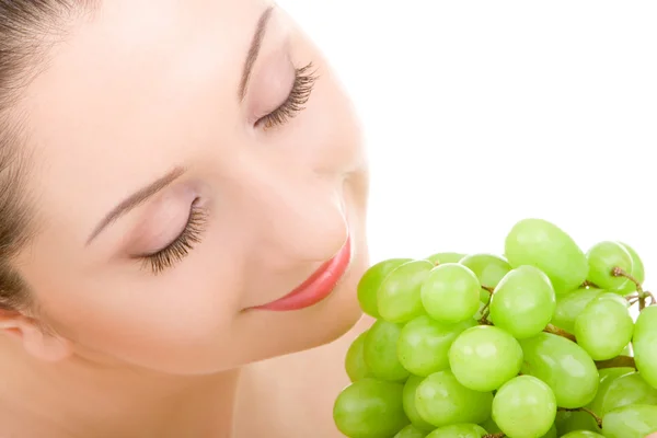 Mooie vrouw met groene druif geïsoleerd op de witte achtergrond — Stockfoto
