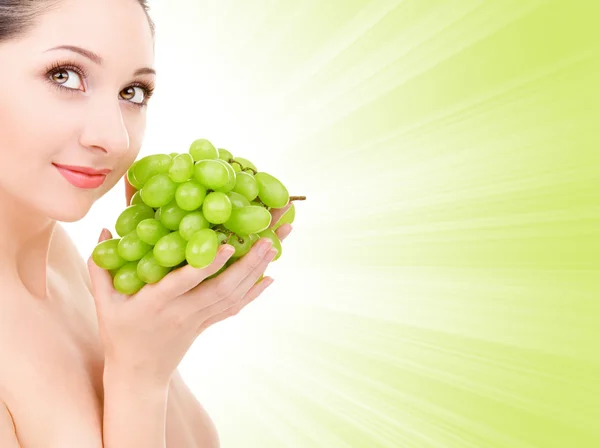 Красивая женщина с зеленым виноградом — стоковое фото