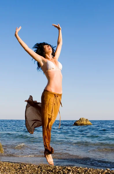 Felice giovane donna che salta in spiaggia — Foto Stock