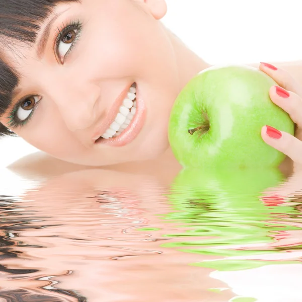 Сладкая девушка ест зеленое яблоко на белом фоне — стоковое фото