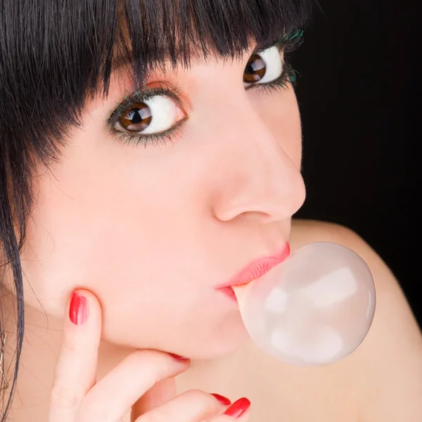 Выражение женщина дует жвачку пузыря — стоковое фото