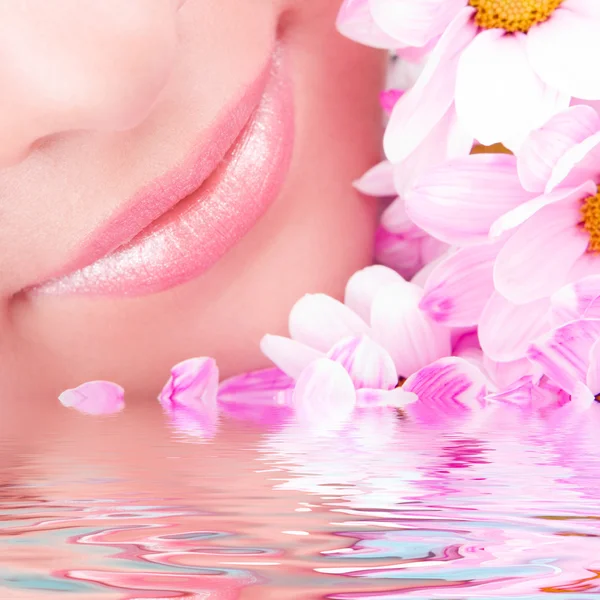 Lächeln einer jungen Frau mit Blumen — Stockfoto