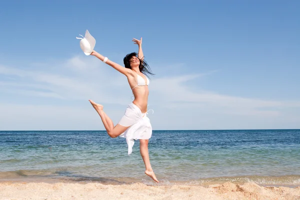 Gelukkig jonge vrouw springen in het strand — Stockfoto