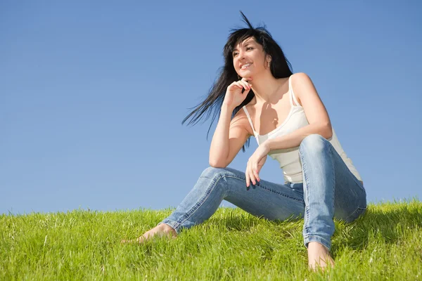 Mutlu genç kadın kalan yeşil çimenlerin üzerinde — Stok fotoğraf