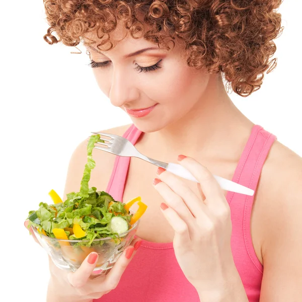 Веселая женщина ест салат на белом фоне — стоковое фото