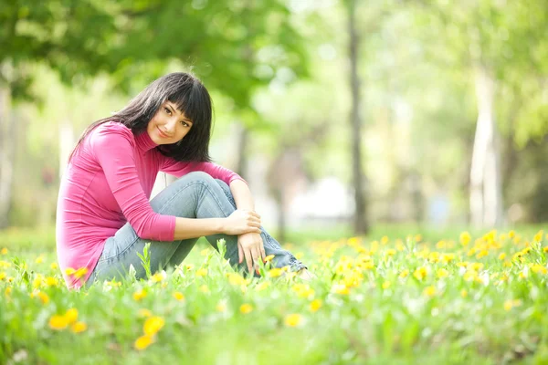 Милая женщина в парке с одуванчиками — стоковое фото
