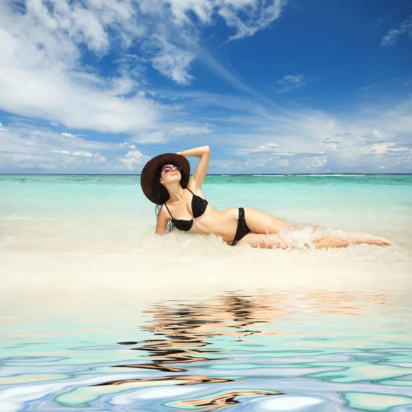 Šťastný módní ženu odpočinku na pláži — Stock fotografie