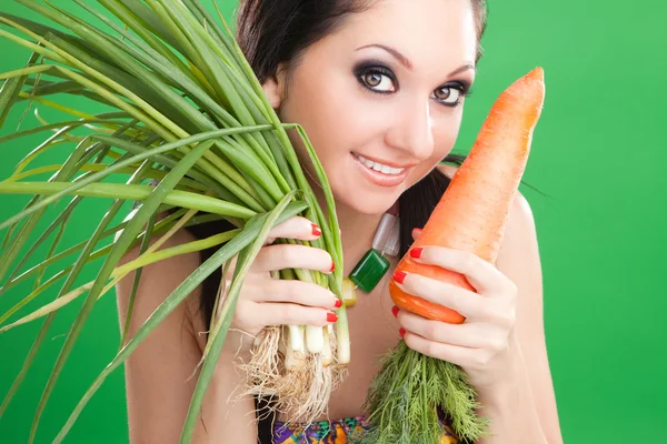 Menina bonita com cenoura e cebola no fundo verde — Fotografia de Stock