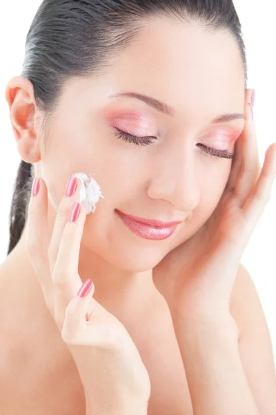 Donna che applica la crema sul viso sullo sfondo bianco — Foto Stock
