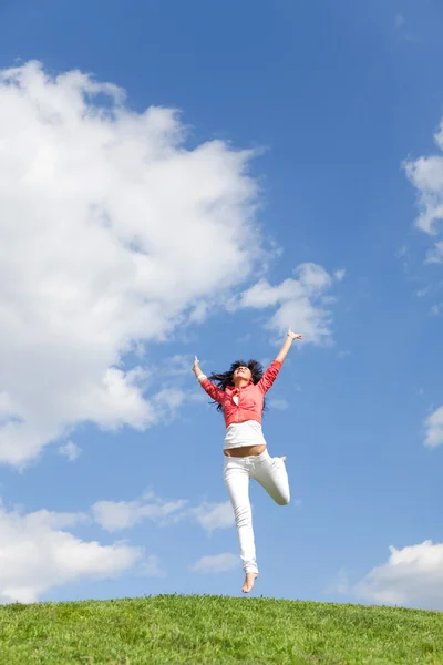 Ganska ung kvinna hoppa på grönt gräs — Stockfoto