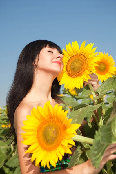 Junge Frau im Feld der Sonnenblumen — Stockfoto
