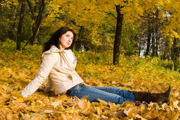 Genç kadın dinlenme sonbahar yaprak üzerinde oldukça — Stok fotoğraf