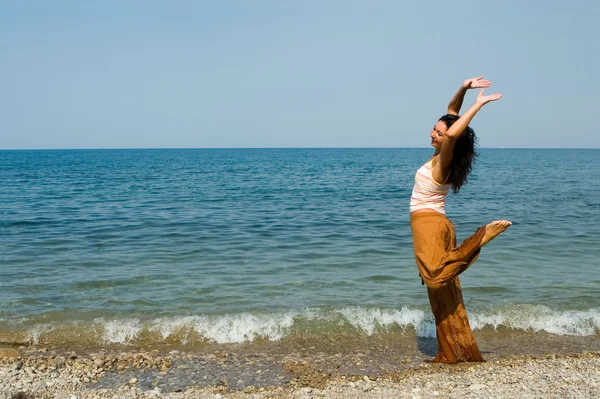 행복 한 젊은 여성이 해변에서 춤을 — 스톡 사진