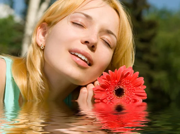 Donna riposo nel parco con fiore — Foto Stock
