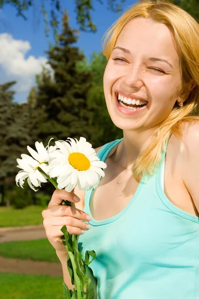 Mujer divertida descanso en el parque con flores —  Fotos de Stock