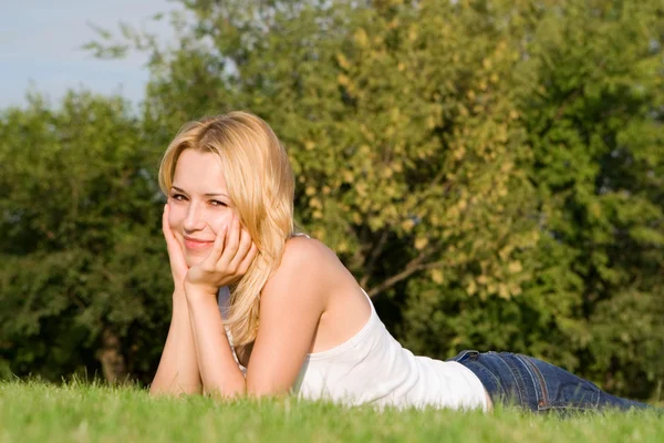 Zoete vrouw rust op het groene gras — Stockfoto