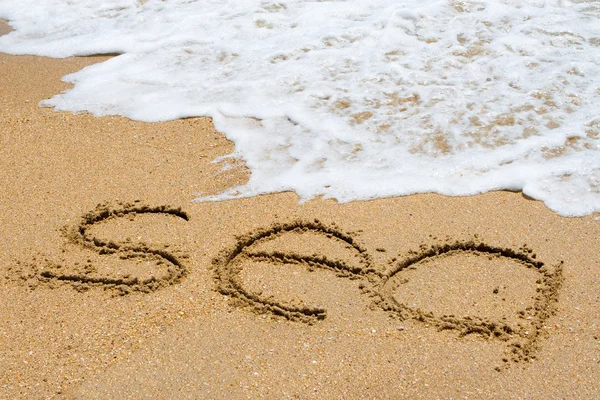 "havet "skrivet i sandstranden — Stockfoto