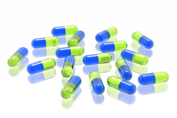 Zielone i niebieskie tabletki na białym tle — Zdjęcie stockowe