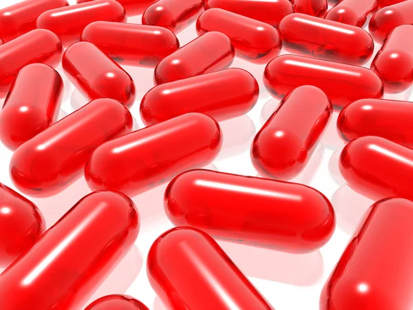 Punainen pillereitä valkoisella taustalla — kuvapankkivalokuva