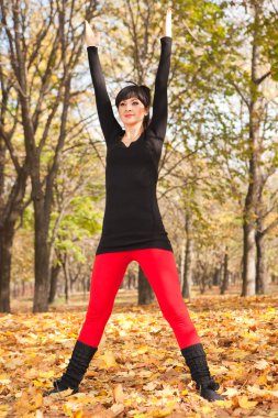 güzel bir kadın yoga egzersizleri sonbahar Park yapıyor